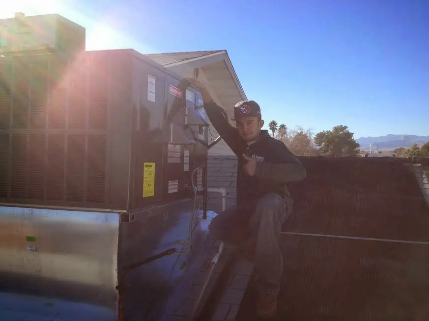 HVAC technician performing Air Duct Cleaning on a rooftop unit in Pleasant Garden